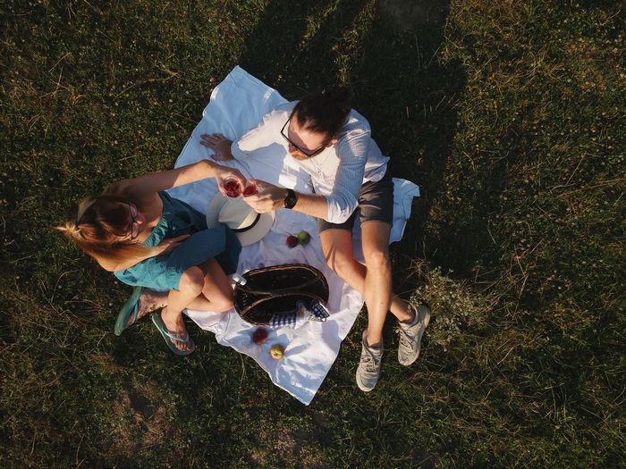 High angle view of couple sitting on picnic blanket