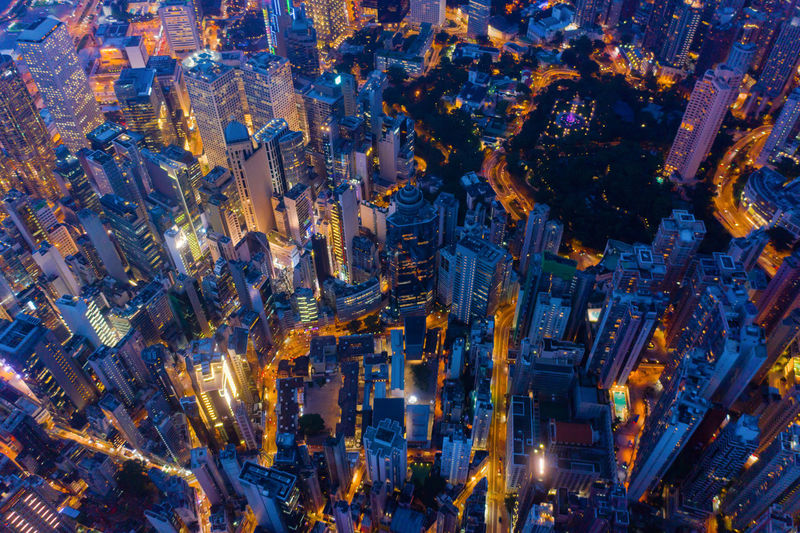 HIGH ANGLE VIEW OF ILLUMINATED CITY BUILDINGS AT NIGHT