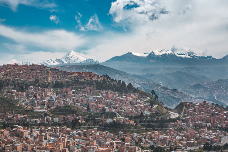 Aerial view of cityscape against cloudy sky