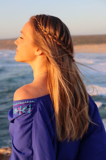 Beautiful woman looking at sea against sky
