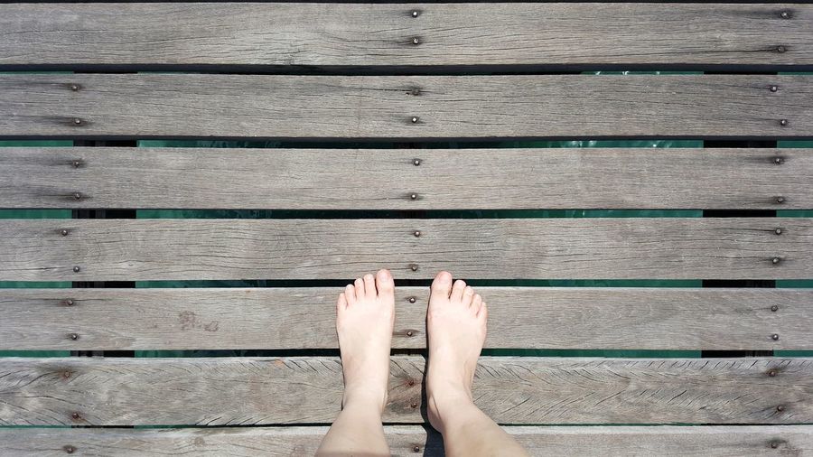 Low section of person legs on pier