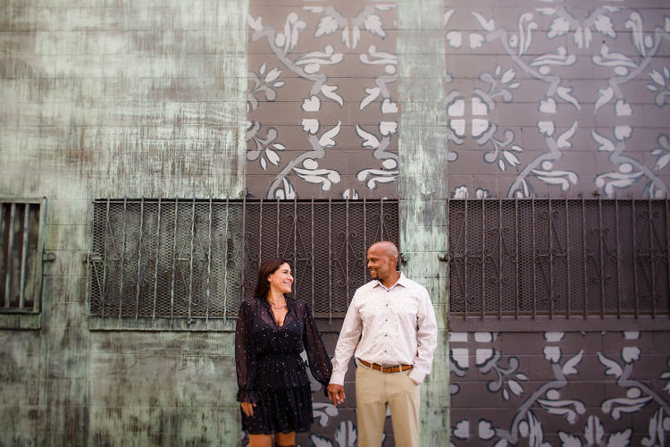 Late forties couple standing in front of mural in san diego