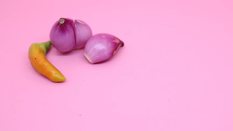 High angle view of chili peppers against pink background