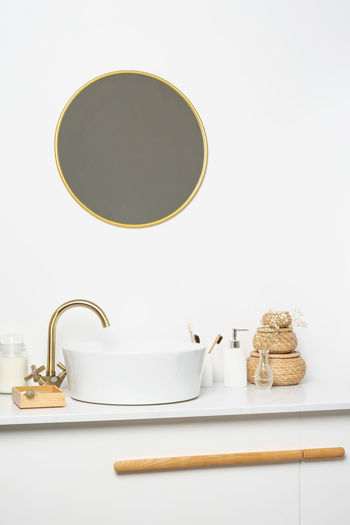 White sink on marble counter with a round mirror hanging above it. bathroom interior. copy space