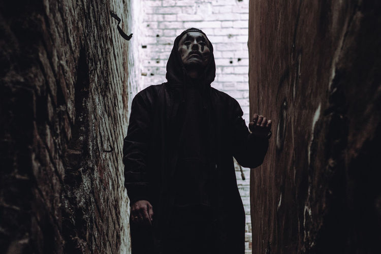 Man wearing mask while standing in alley