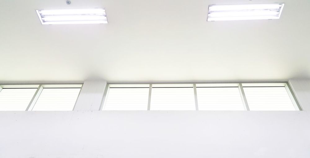 Low angle view of illuminated lights on ceiling of building