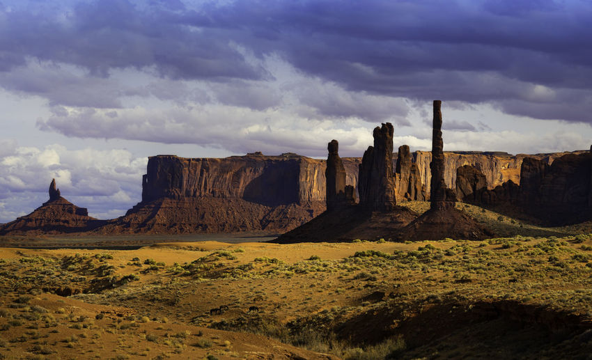 Panoramic view of rock formations on landscape against cloudy sky