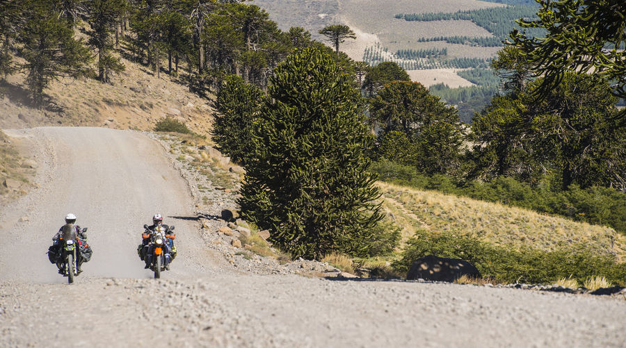 Couple on touring motorbikes driving on gravel road in argentina
