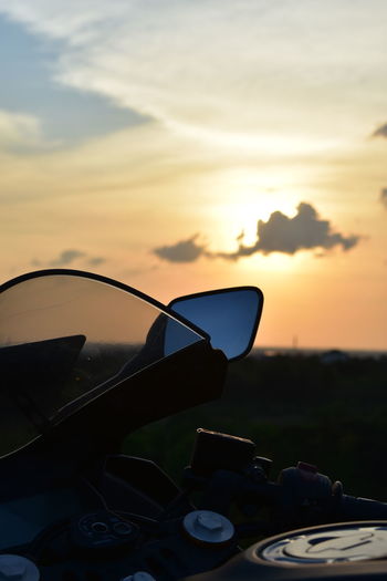 Close-up of sunglasses against sky at sunset