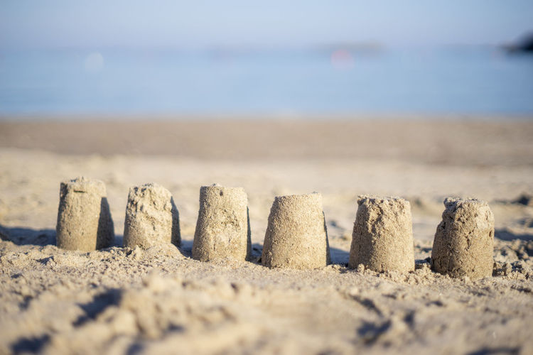 Close-up of sandcastle on beach against sky