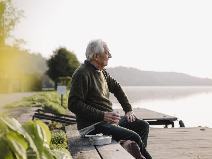 Senior man looking at view while sitting on bench