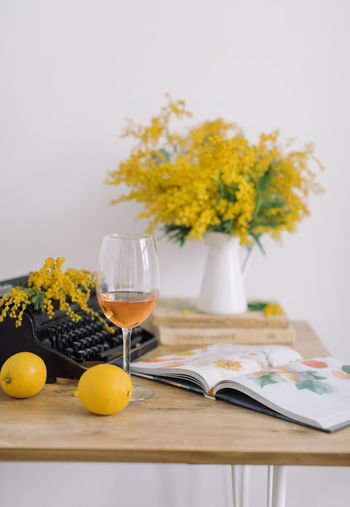 Yellow flowers and wine on table