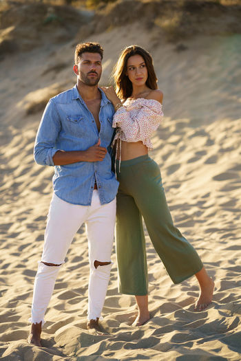 Full length of couple standing at beach