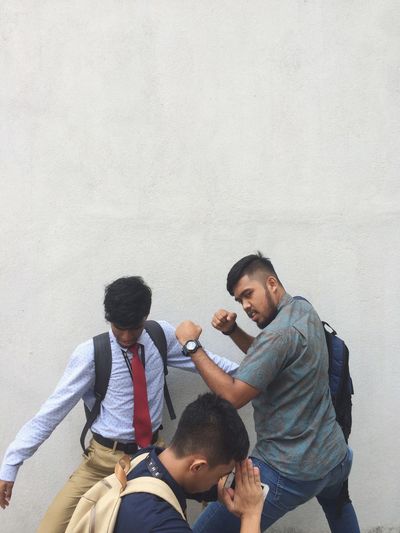 Friends posing against wall