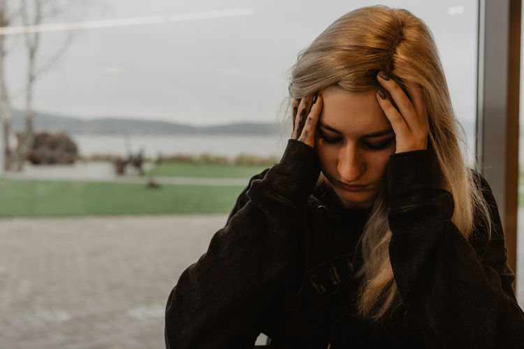 Portrait of young woman in warm clothing, depression / mental health, sad woman 