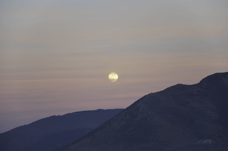Full moon on cloudy sky at dusk