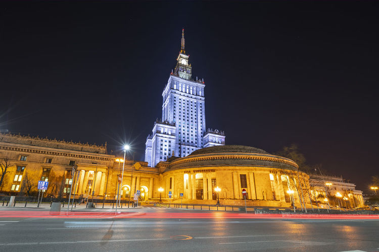 Palace of culture and science by road in city at night
