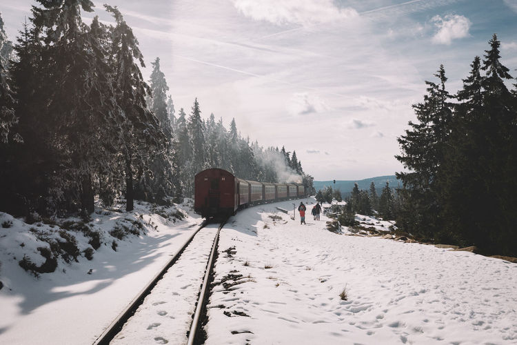 Train on track during winter against sky