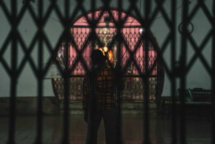 Reflection of woman standing in illuminated building