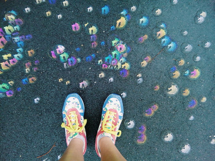Low section of person standing on street by bubbles