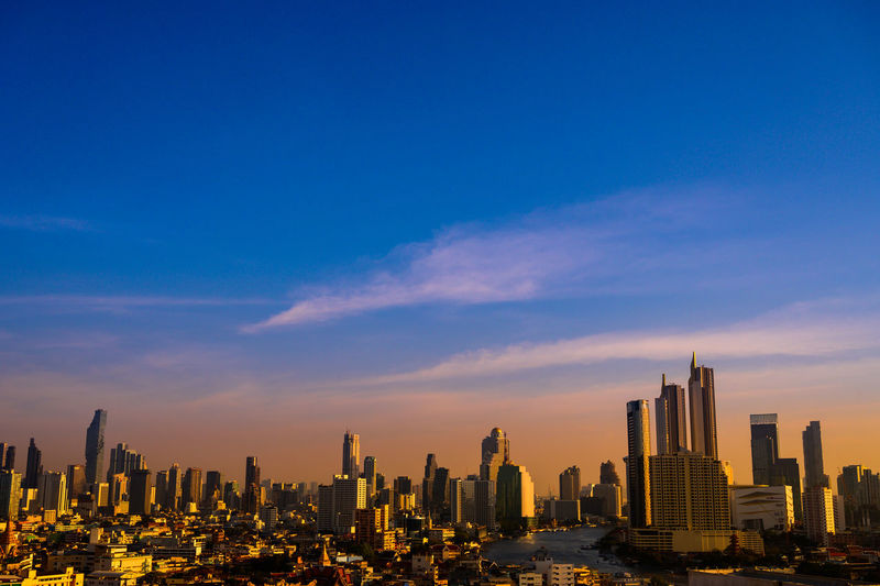 Modern buildings in city against blue sky