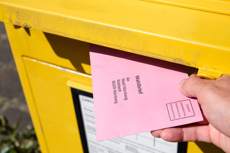 Cropped hand if person putting mail in box