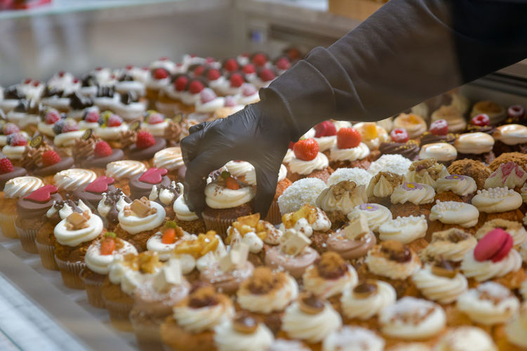 Confectioner placing cakes on a showcase for sale