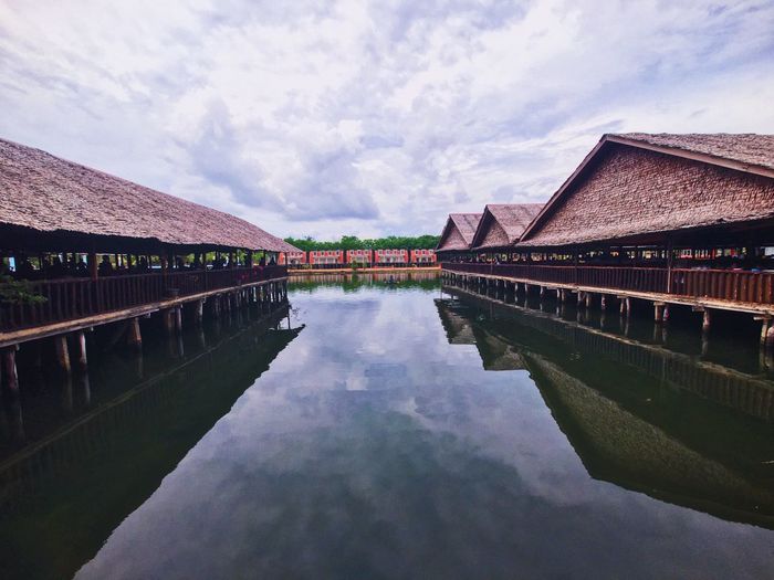 Reflection of houses in lake against sky