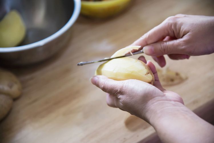 Cropped image of person holding fruits on table