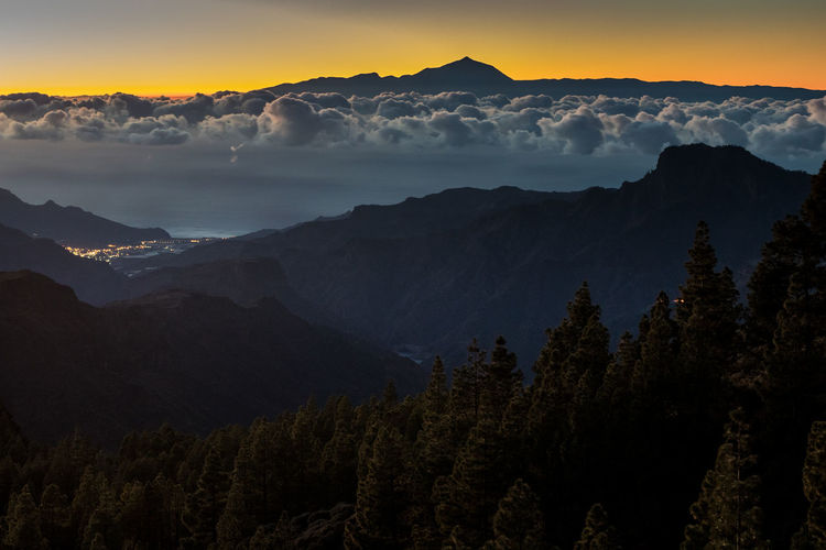 Scenic view of silhouette mountains against sky at sunset