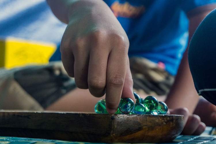 Low section of boy playing marbles