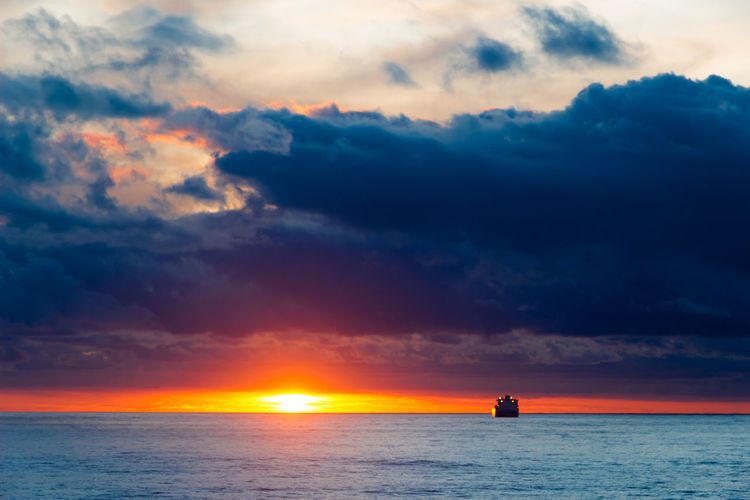 Sea sunset landscape with ship on the horizon