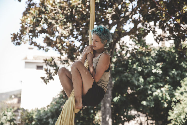 Young woman with blue hair doing acrobatics