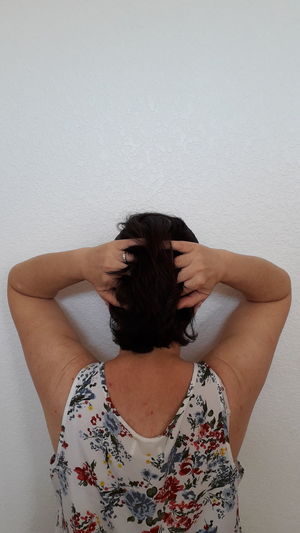 Midsection of woman standing against wall