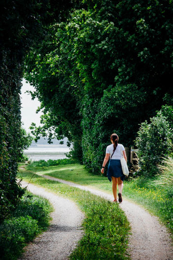 Rear view of woman walking on footpath at park