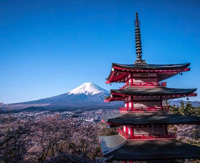 Traditional windmill on mountain against blue sky