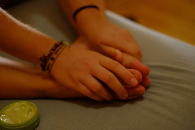 Close-up of hands massaging feet