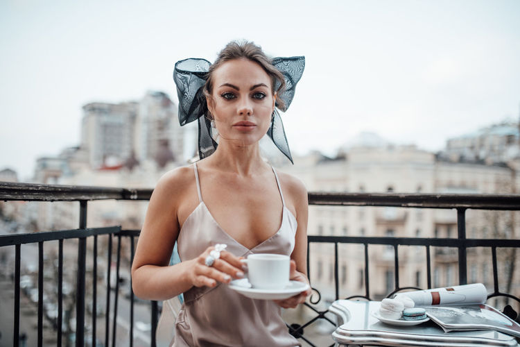 Young woman with coffee cup in balcony