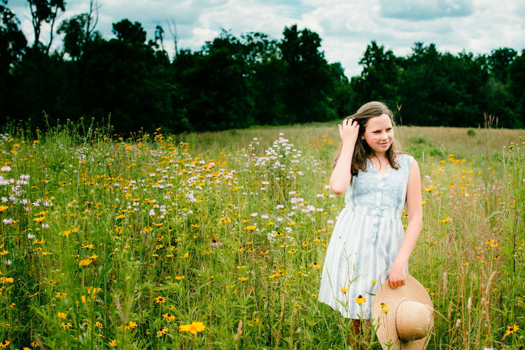 Young woman standing among flowers in a field