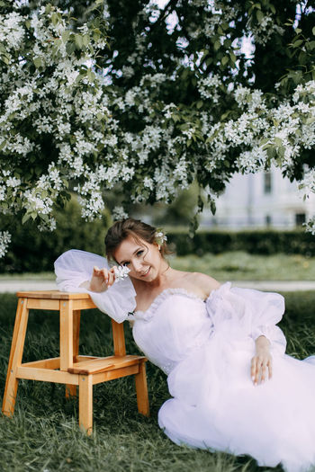 A beautiful delicate elegant young woman bride in a wedding dress walks in a spring outdoor park