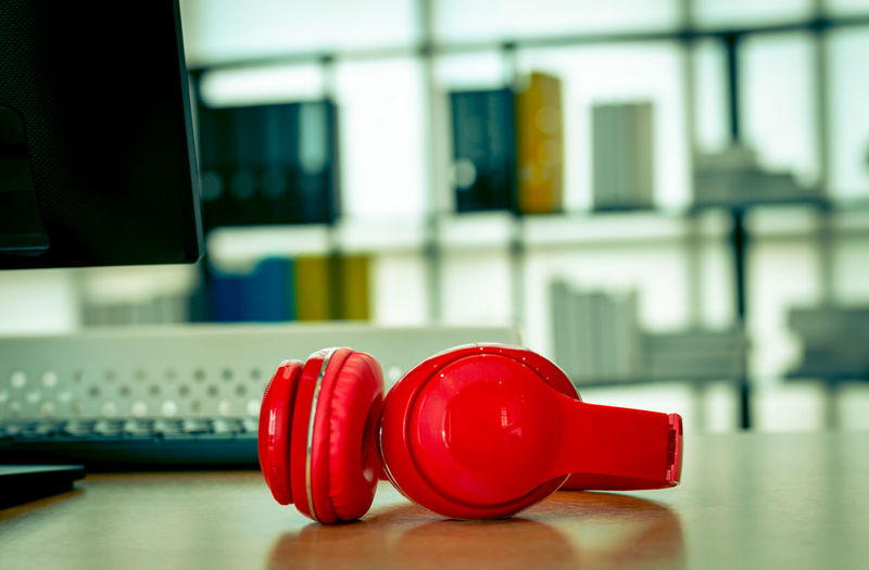 Red headphone on desk in office, business office background concept.