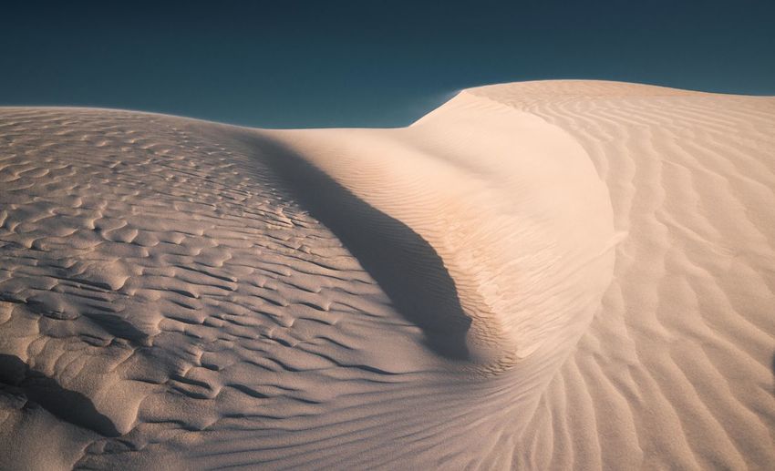 Tilt image of sand dunes in desert against sky
