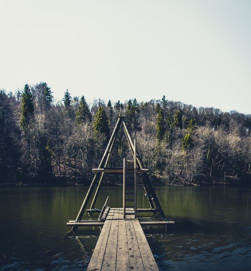 Pier over lake against clear sky