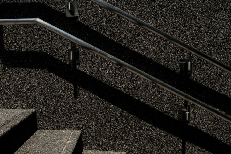 High angle view of railing shadow on staircase