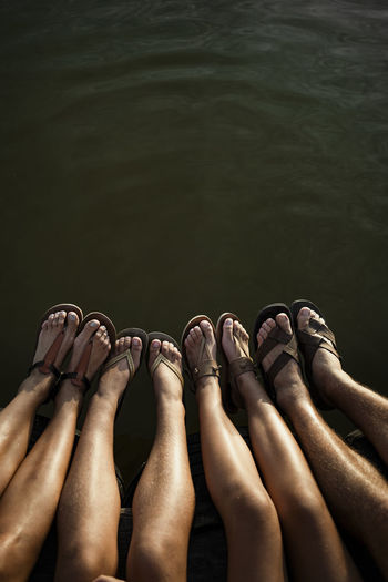 Family legs dangling over lake