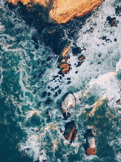 High angle view of sea by rock