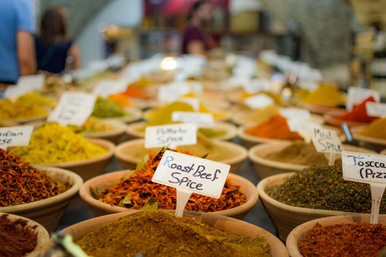 Close-up of spices with labels in bowls for sale at store