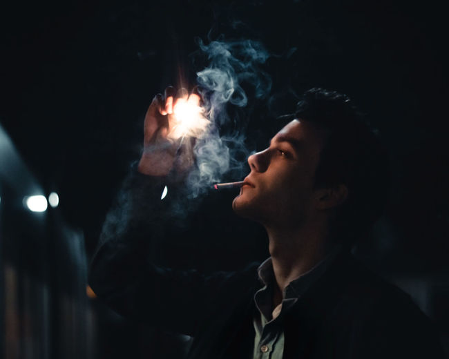 Man smoking cigarette at night