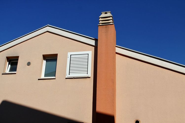 Low angle view of building against clear blue sky