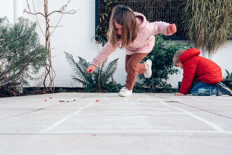 Children playing hopscotch in a terrace outdoors - leisure time
